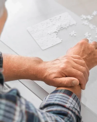 senior-man-with-parkinson-syndrome-doing-puzzle-home